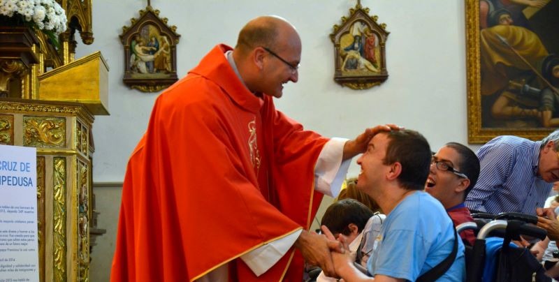 Ricardo Alvarado bendiciendo discapacitado